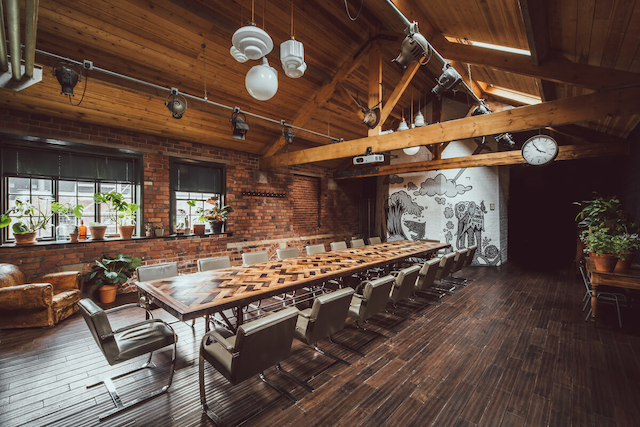 Photograph of the meeting room at the Chimney House, Sheffield. A long wooden conference table in a converted 19th century factory